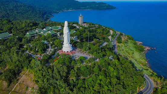 A drone view of a huge Buddha statue on a hill next to the coast, in Vietnam, Asia,