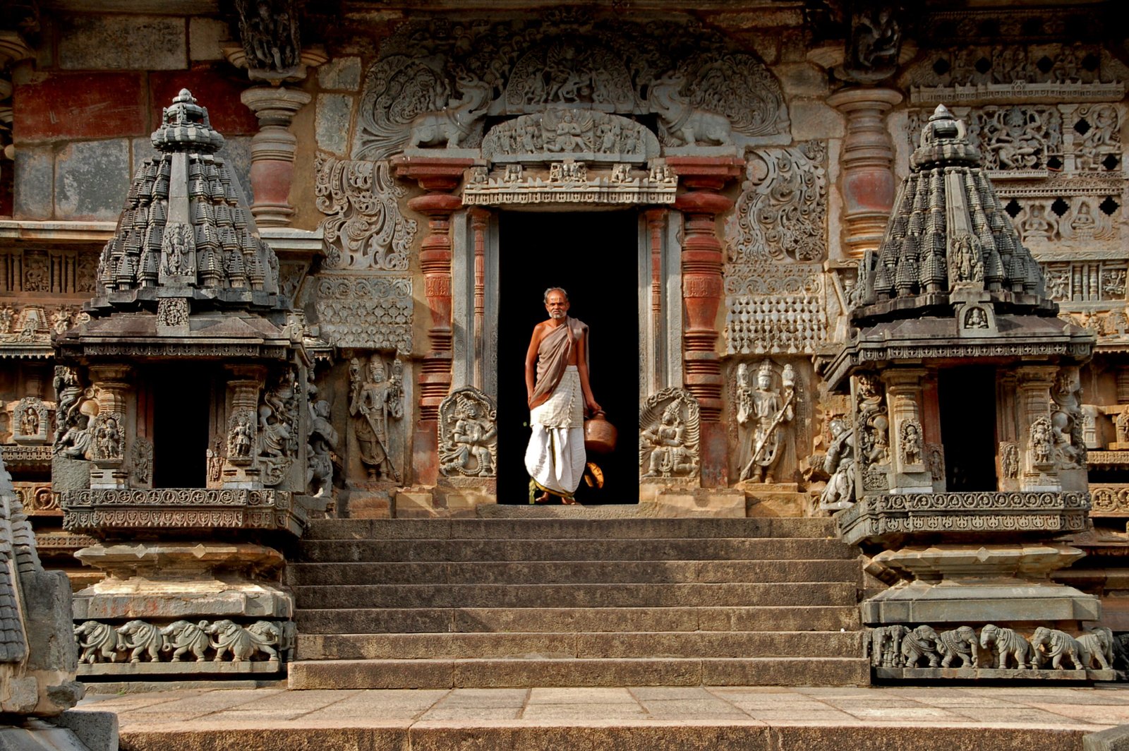"Belur, India - november 16, 2006: a monk caring a pitcher in Chennakesava Temple in Belur, India."